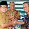 Sekda Kuningan saat memberikan cinderamata kepada Dosen Unpas Bandunf.